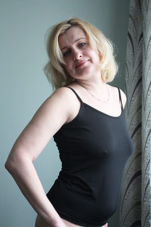 Голая женщина курит возле окна 2 фото