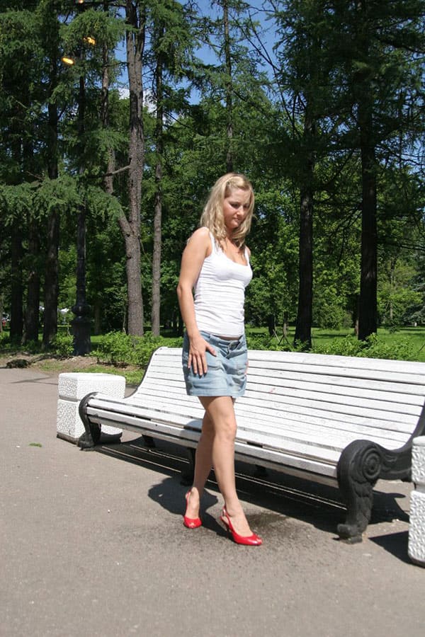 Блондинка открыто писает на скамейке в парке 14 фото