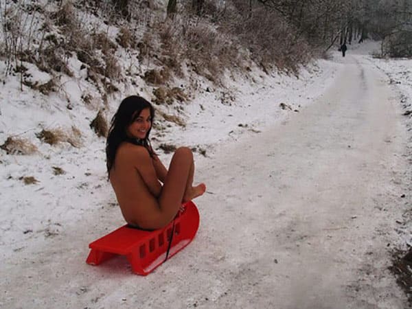 Брюнетка голышом катается на санках по снегу 9 фото